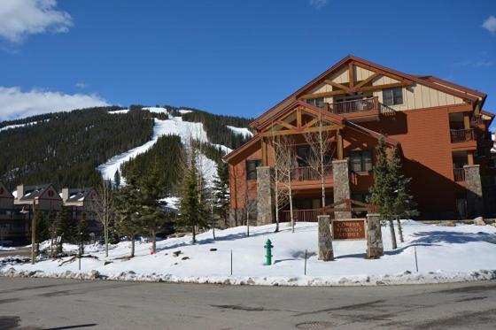 a large building with a green fire hydrant in the snow at Copper Springs 426 in Frisco