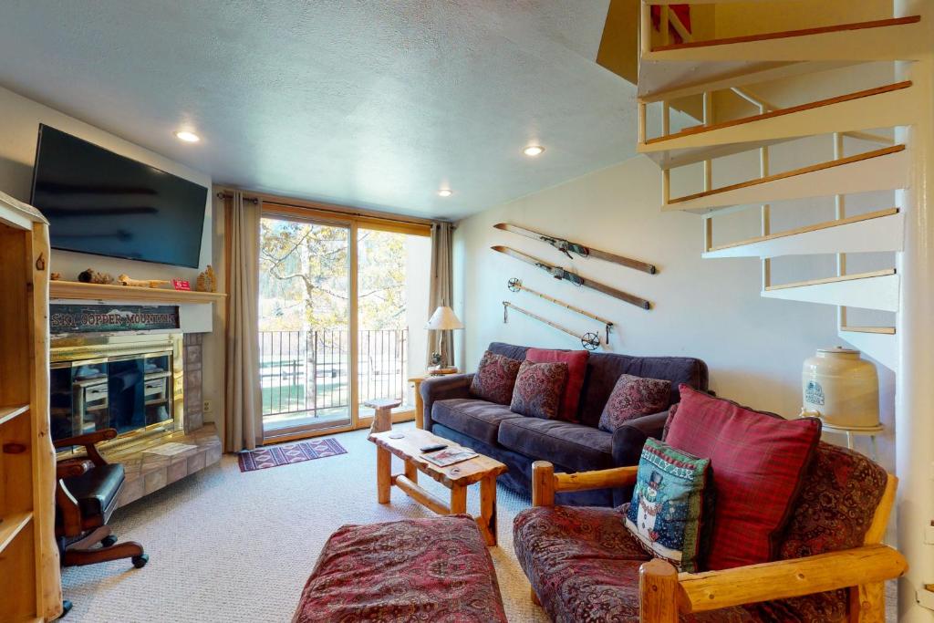 a living room with a couch and a tv at Summit House East 113 in Copper Mountain