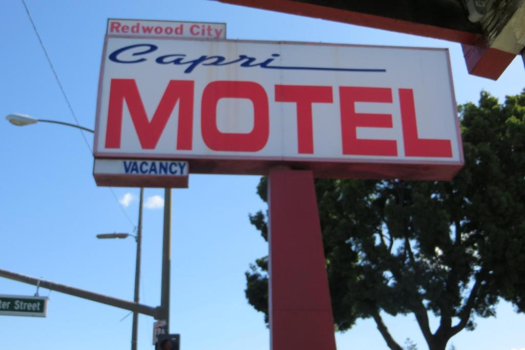 a sign for a metel gas station at Capri Motel in Redwood City