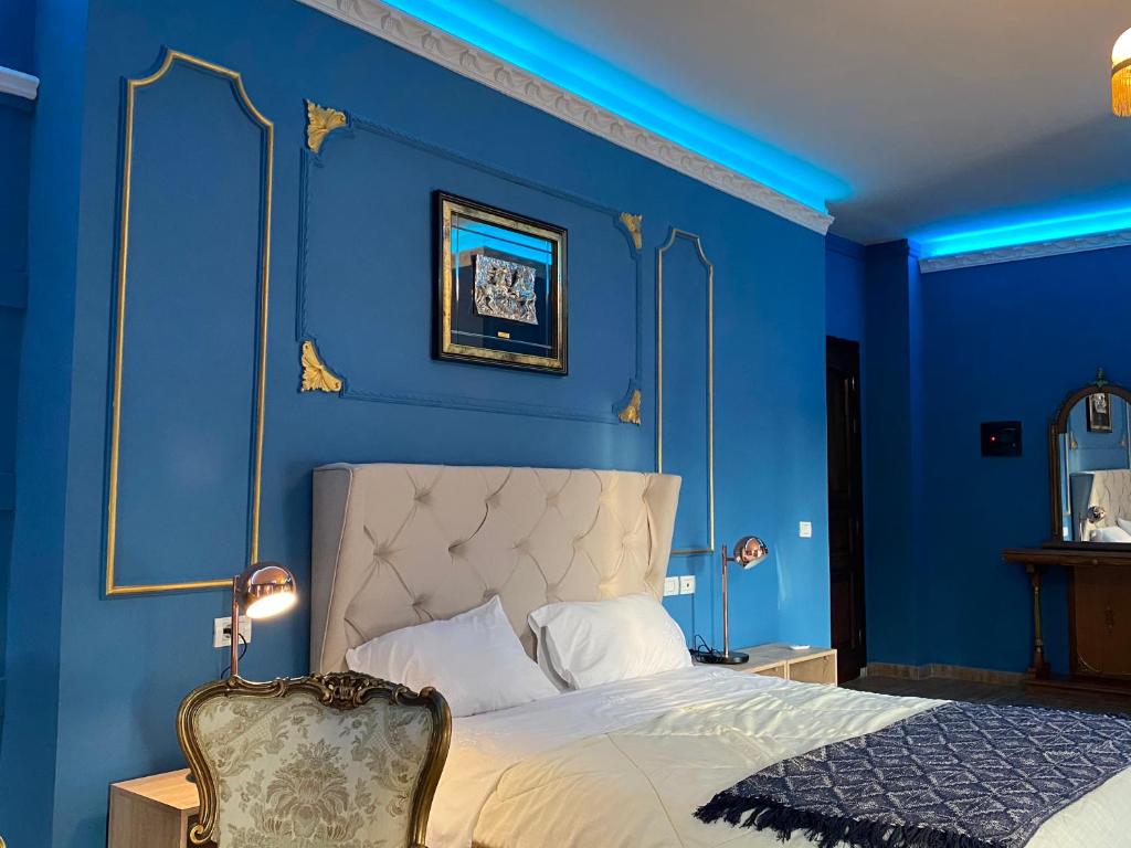 um quarto azul com uma cama e uma cadeira em Hotel Internacional Gym & Spa Fushe-Arrez em Fushë-Arrëz