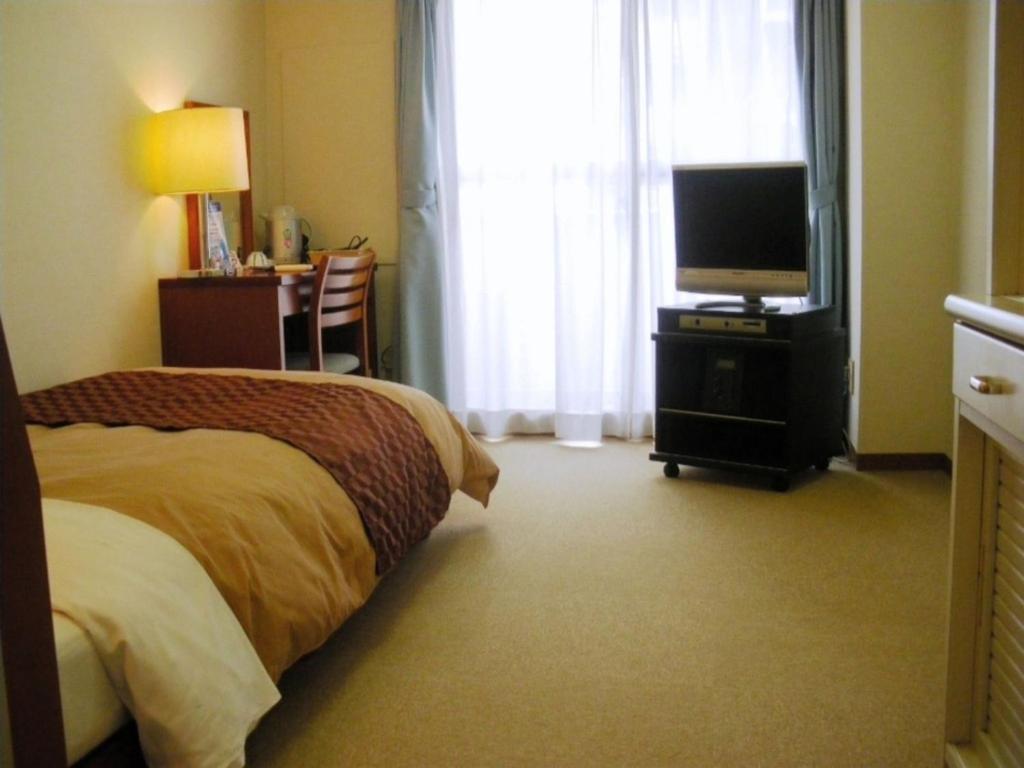 una camera d'albergo con letto e TV di Sky Heart Hotel Kawasaki - Vacation STAY 97869 a Kawasaki