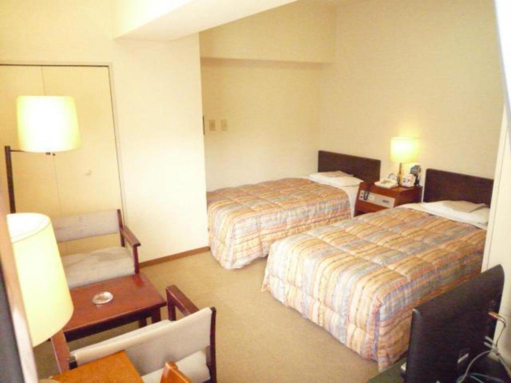 Habitación de hotel con 2 camas y mesa en Sky Heart Hotel Kawasaki - Vacation STAY 97877, en Kawasaki