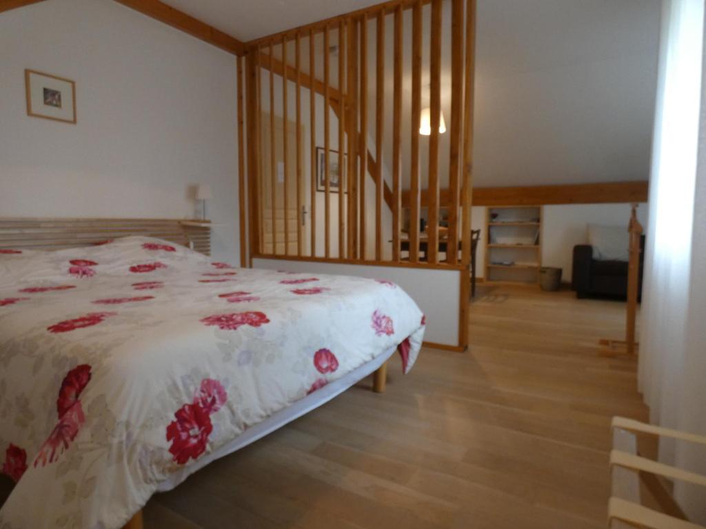 a bedroom with a bed and a wooden floor at les iris in Villevieux