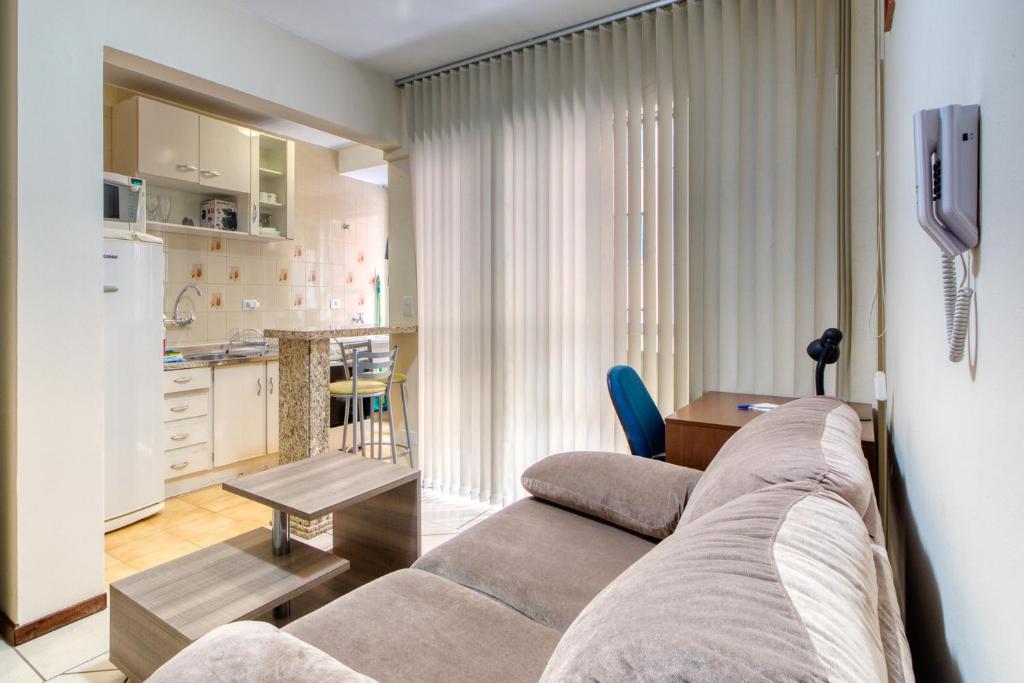 Il comprend un salon avec un canapé et une cuisine. dans l'établissement Ótimo apartamento no Centro mobiliado e com garagem, à Curitiba