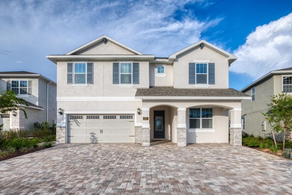 a large white house with a driveway at Gleaming Home by Rentyl with Theater Room near Disney - 209S in Orlando
