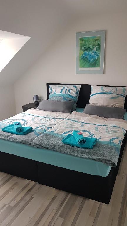uma cama com duas toalhas azuis em cima em Hohenlohe -Residenz-Svetlana em Langenburg