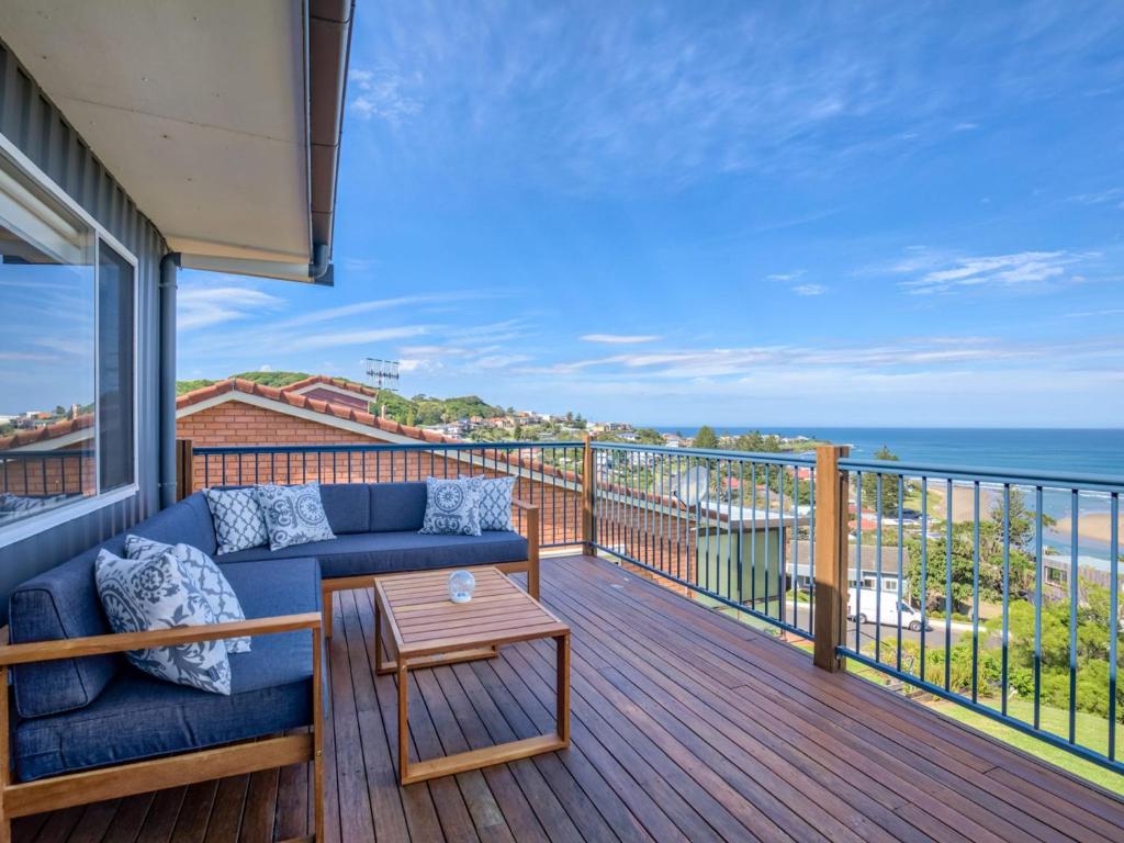 um sofá azul numa varanda com vista para o oceano em Grand View Gerroa em Gerroa