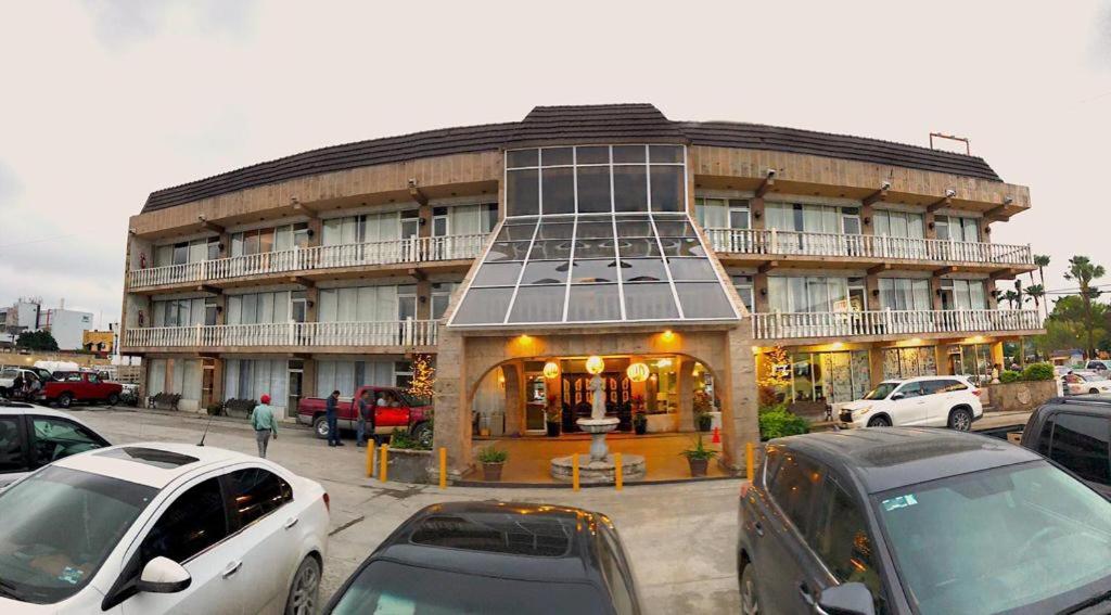 a large building with cars parked in front of it at HOTEL PLAZA RIVIERA in Matamoros