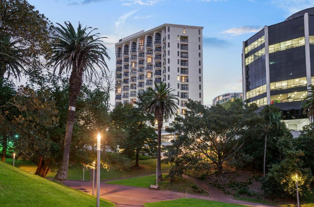 ein hohes Gebäude in einer Stadt mit Palmen in der Unterkunft Parkside Hotel & Apartments in Auckland