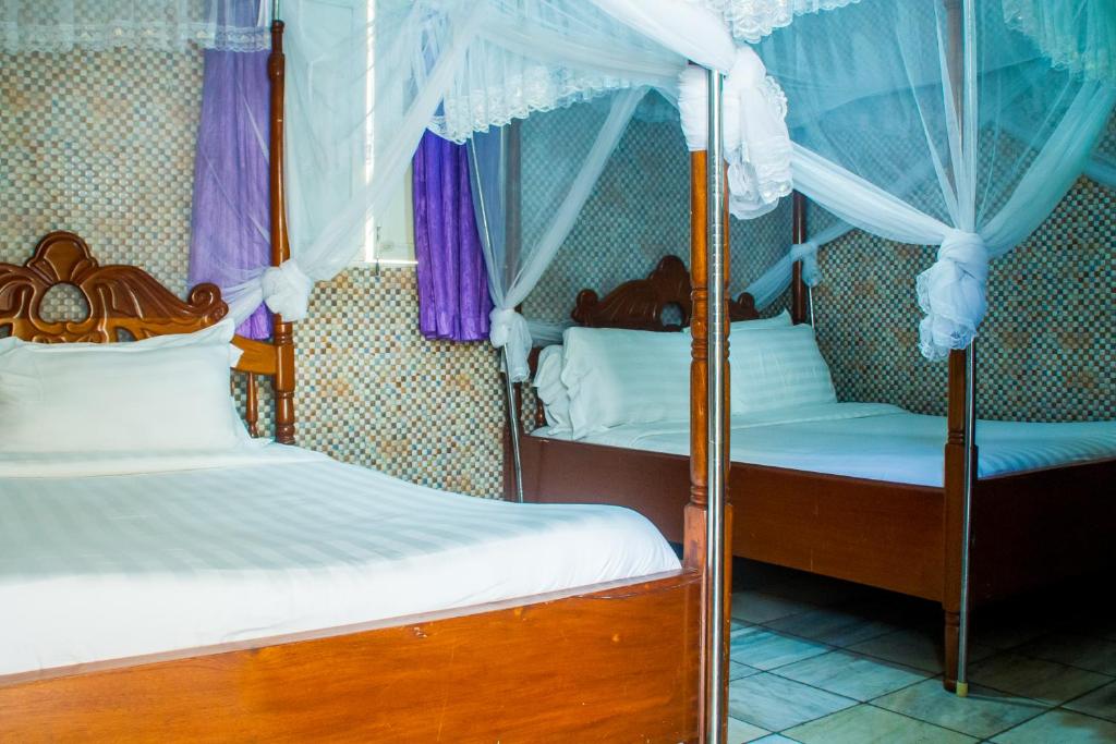 Postel nebo postele na pokoji v ubytování Sandton Hotel Kasese