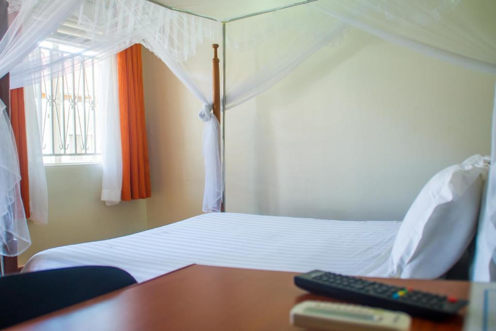 Postel nebo postele na pokoji v ubytování Sandton Hotel Kasese