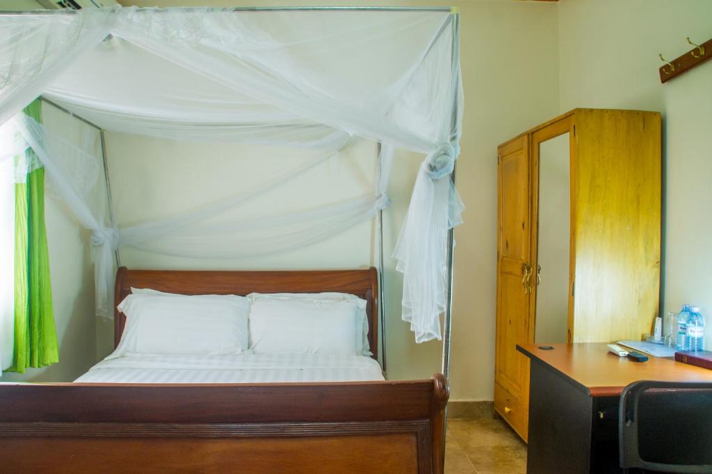 Postel nebo postele na pokoji v ubytování Sandton Hotel Kasese