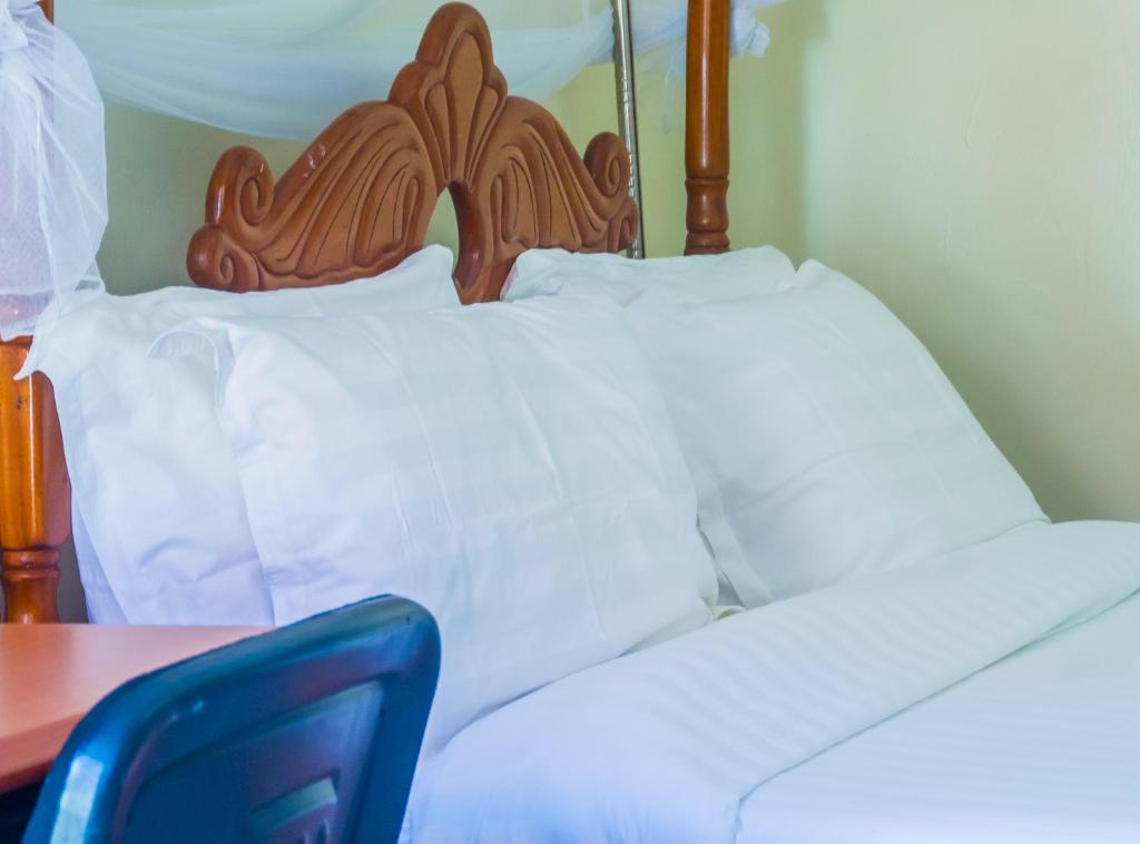 Postel nebo postele na pokoji v ubytování Sandton Hotel Kasese