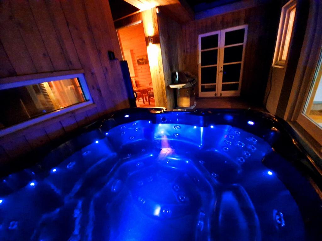 Una gran bañera azul en una habitación con ventana en Adventure Eagle Cottege en Geysir