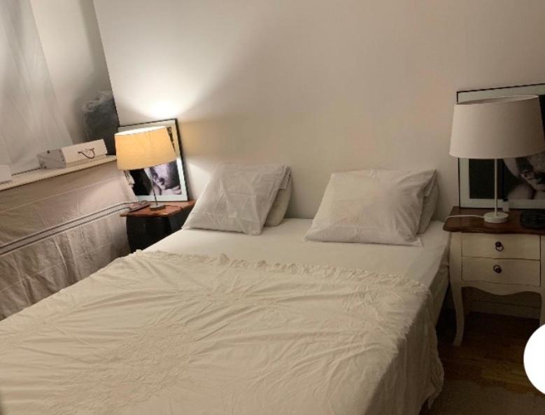 1 dormitorio con 1 cama con sábanas y almohadas blancas en Agréable Logement à Vierzon, en Vierzon