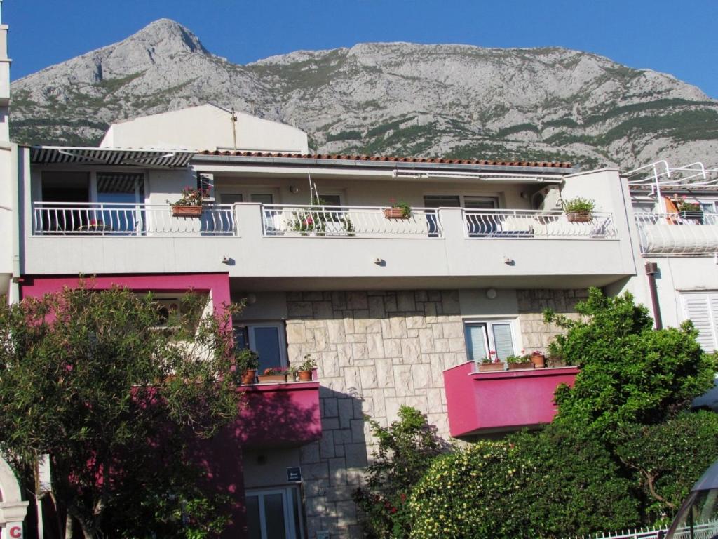 un edificio con una montagna sullo sfondo di Urban Apartments Jadre a Makarska