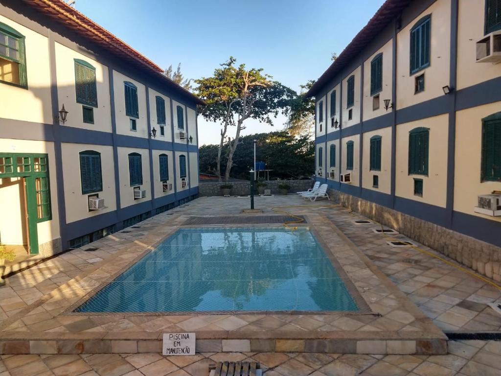 a swimming pool in the courtyard of a building at Lindo Flat em frente a Praia do Peró - Cabo Frio in Cabo Frio