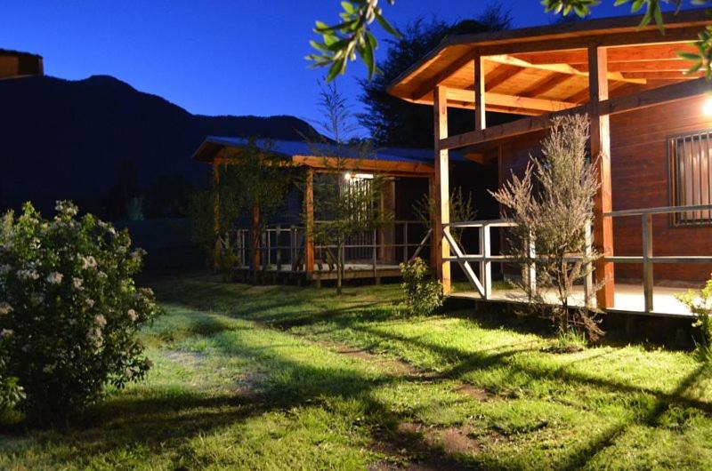una casa con un patio de hierba delante de ella en Cabañas Las Bandurrias del Caburgua, en Pucón