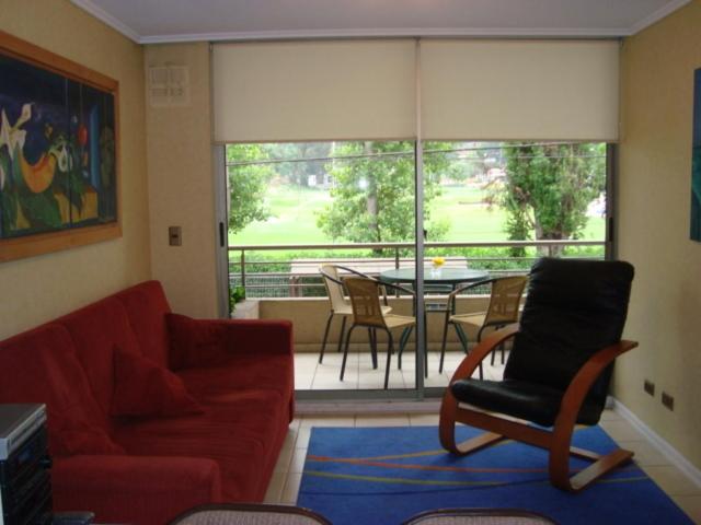sala de estar con sofá, silla y mesa en Departamento Reñaca Torremolinos XII, en Viña del Mar
