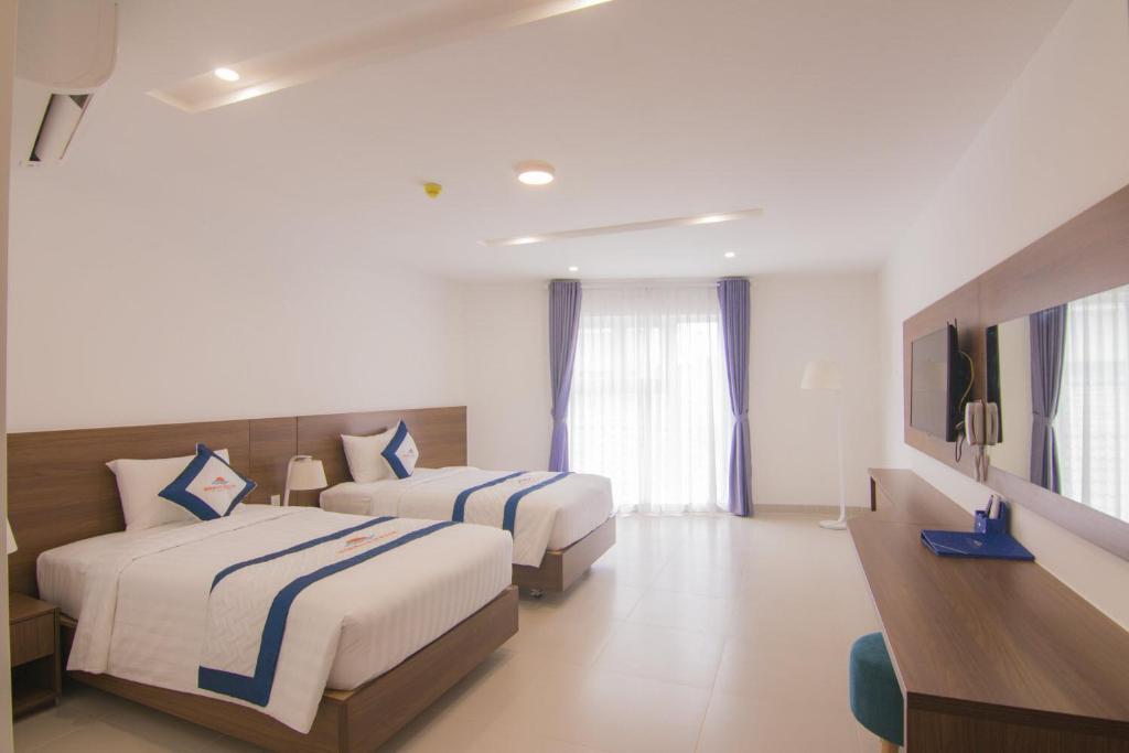 Postel nebo postele na pokoji v ubytování Mermaid Seaside Hotel