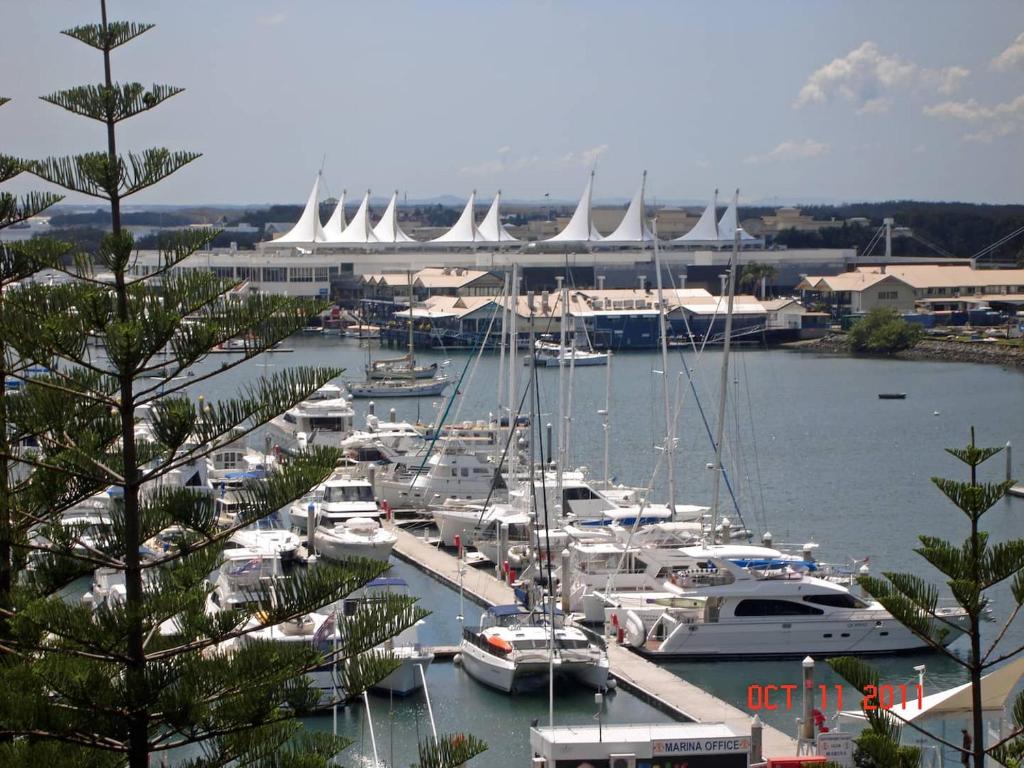 a bunch of boats docked in a marina with a stadium at Main Beach Waterfront Apartment in Gold Coast