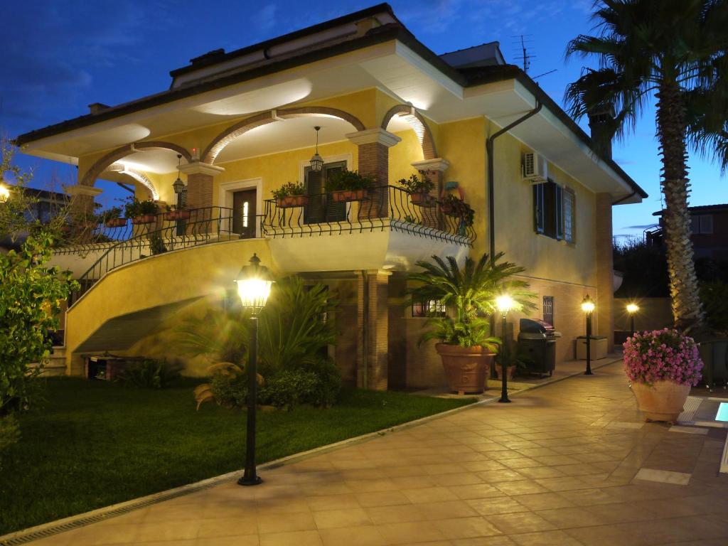 a large house with a balcony and a courtyard at Alba Chiara in Anzio