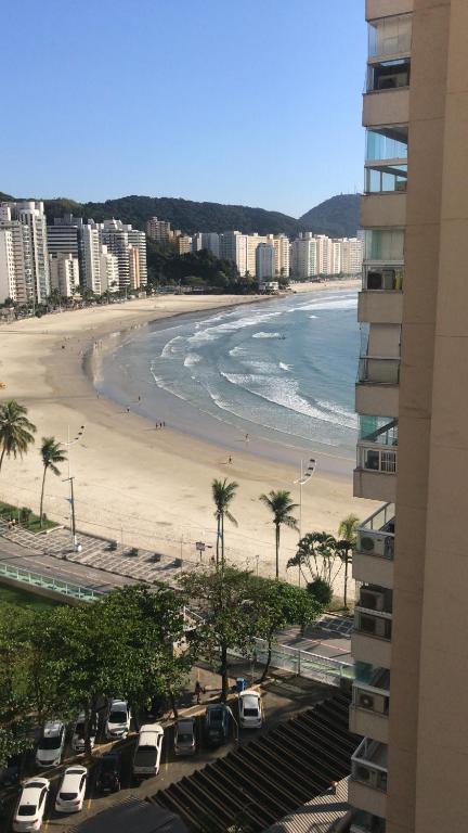 uma vista para uma praia com palmeiras e edifícios em ASTURIAS Frente ao mar no Guarujá