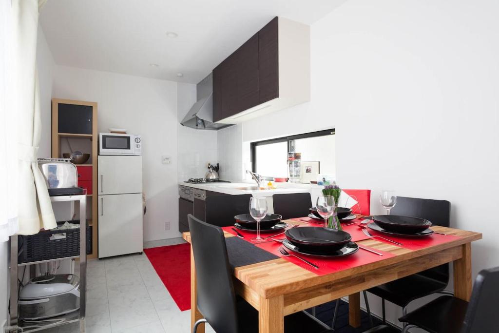 Hotel Pencil House - 10 mins walk to Shinjuku, a kitchen with a wooden table with black bowls on it at Pencil House - 10 mins walk to Shinjuku in Tokyo