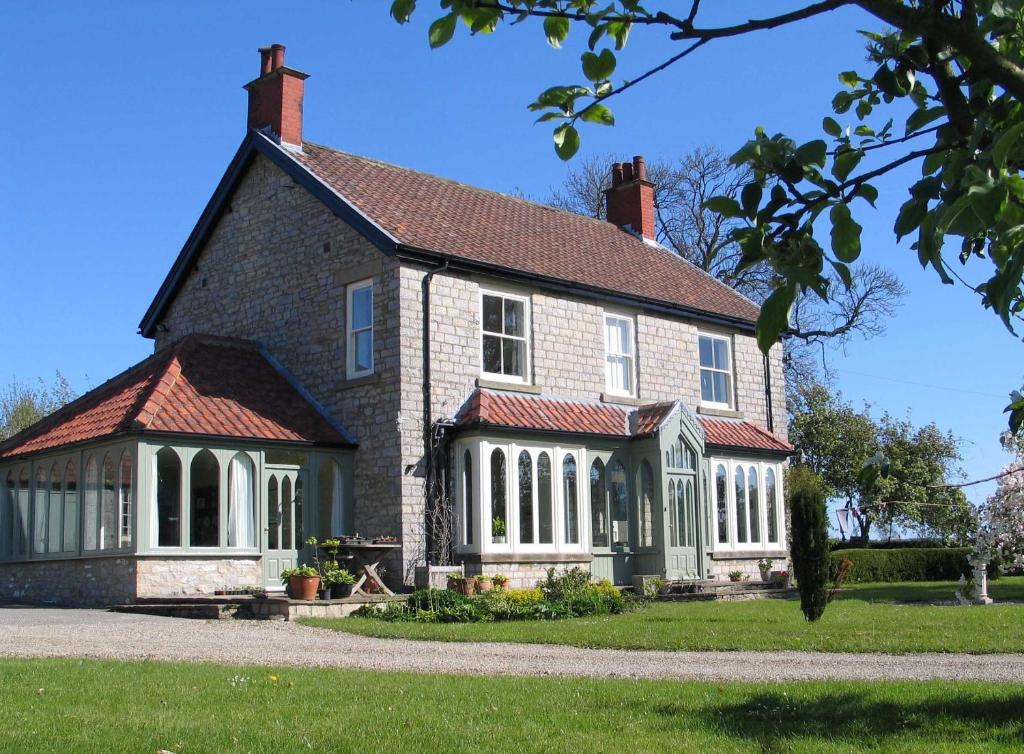 a large brick house with white columns at High Rigg B&B in Helmsley