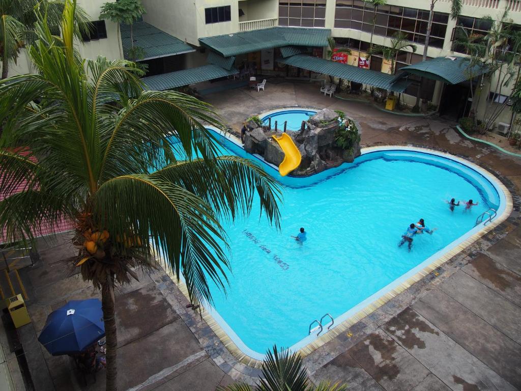 an overhead view of a large swimming pool with people in it at Pangkor Coral Bay Resort(2 bedrooms) in Pangkor