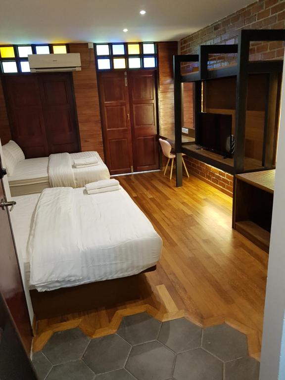 a bedroom with two bunk beds and a flat screen tv at Little Kampung Studio in Teluk Intan