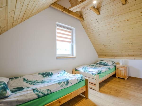 a attic room with two beds and a window at Czadzia Przystań in Czarna