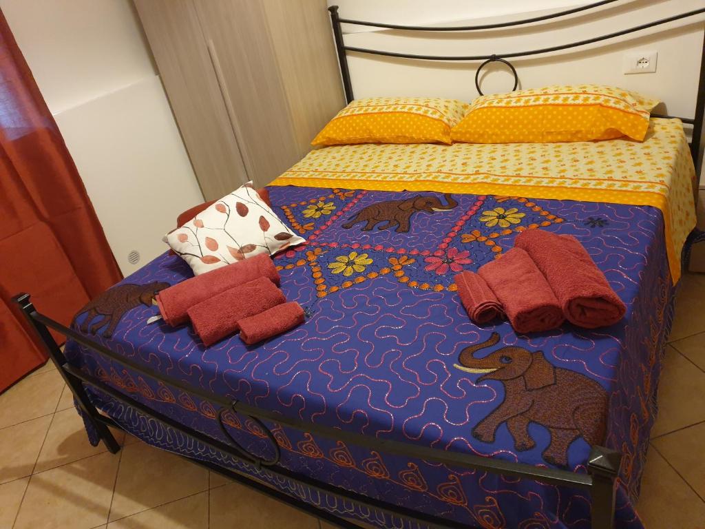 ein Bett mit Decken und Kissen darauf in der Unterkunft casa epomeo in Catania