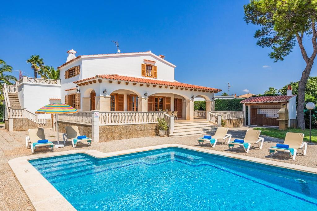 a villa with a swimming pool in front of a house at Villa Menorca Jalima 1 by Mauter Villas in Cala Blanca