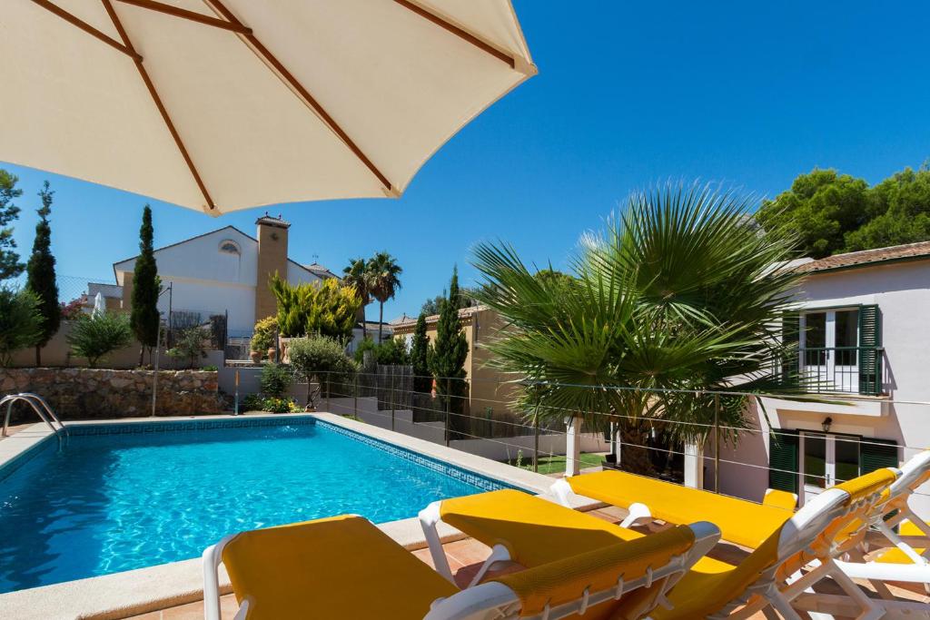 ポリェンサにある4 bedrooms villa at Pollensa 100 m away from the beach with sea view private pool and enclosed gardenのスイミングプール(椅子、パラソル付)