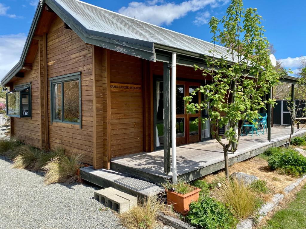 a log cabin with a porch and a tree at Lockwood on Aorangi in Lake Tekapo