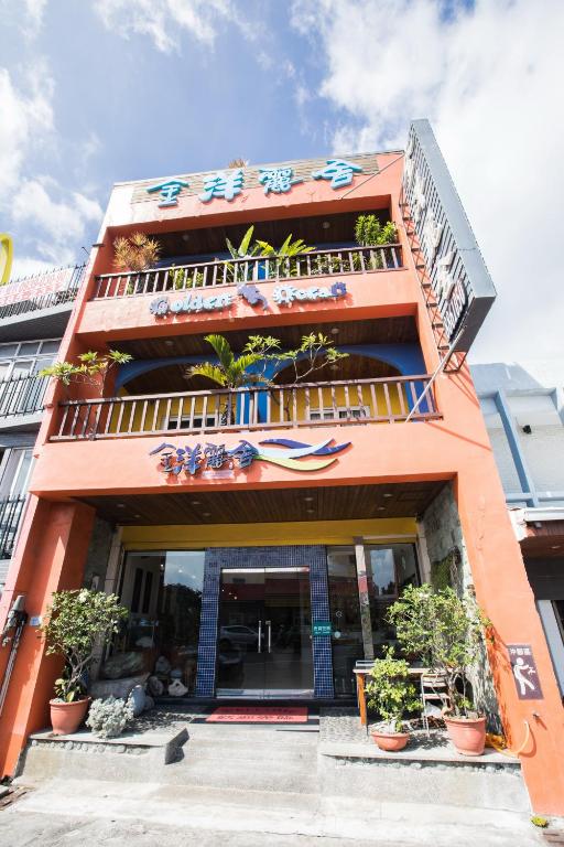 an orange building with a surfboard on it at Golden Ocean Azure Hotel in Kenting
