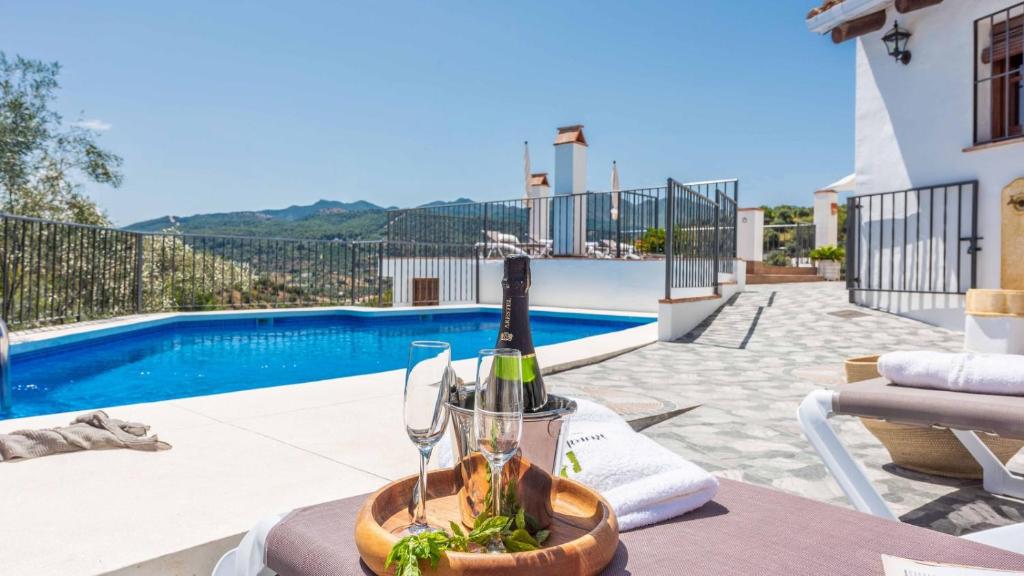 una botella de vino en una mesa junto a una piscina en Casa Guajar 2 Monda by Ruralidays en Monda