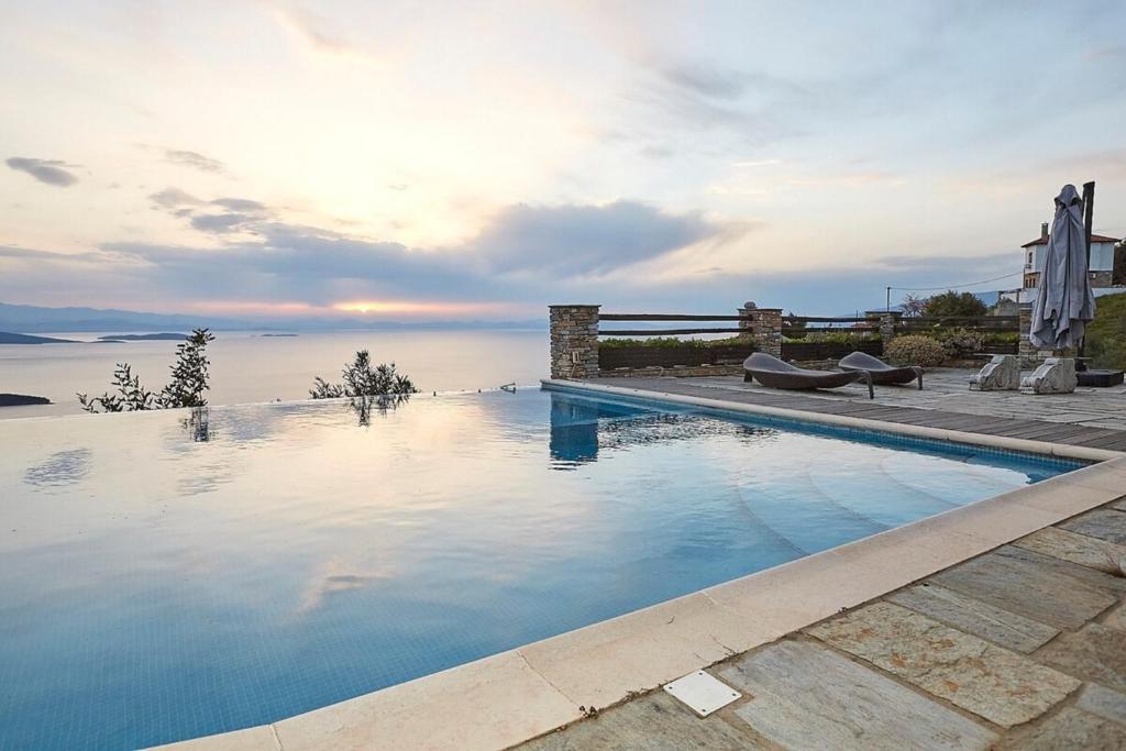 a swimming pool with a view of the water at Black Diamond Luxury Unique Villa Pelion in Lafkos