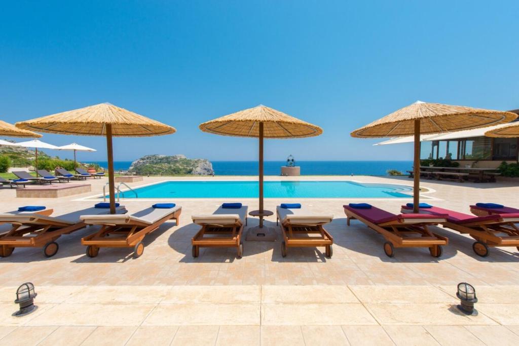 ファリラキにあるBlack Diamond Villa Pasithea in Rhodes Greeceのプール(椅子、パラソル付)