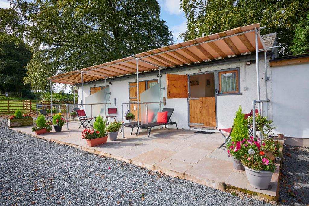 a house with a patio with potted plants at Newlands Farm Stables in Kendal