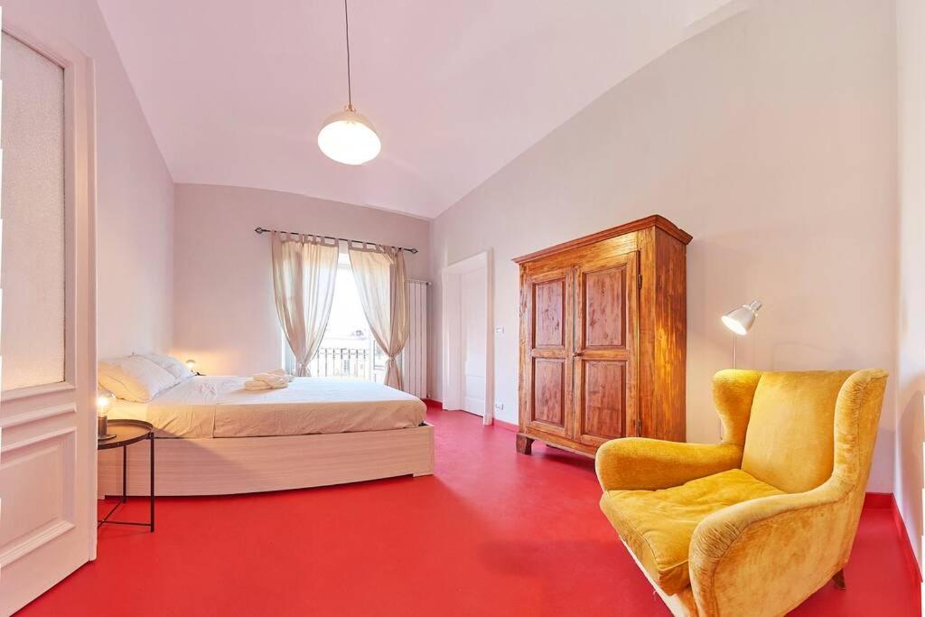 um quarto com uma cama e uma cadeira em Domus Mazzini em Turim