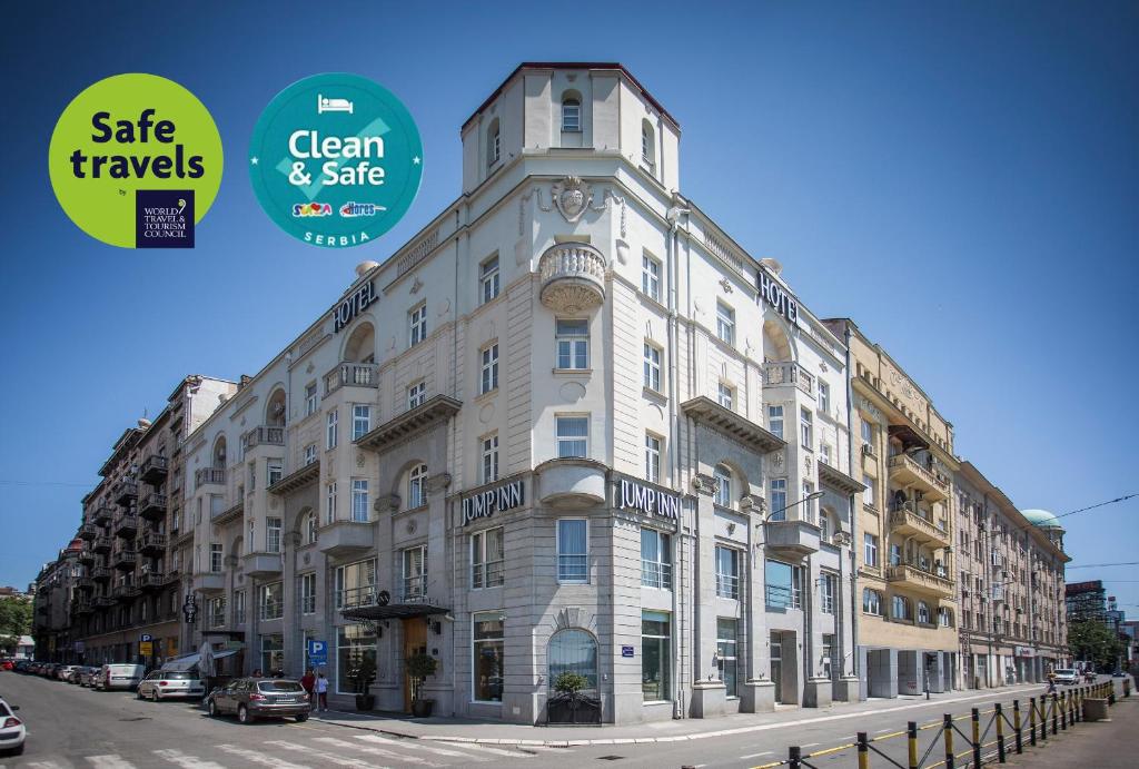 a large white building with a clock on the side of it at Jump INN Hotel Belgrade in Belgrade