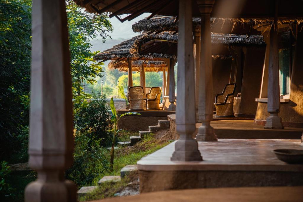 an outside view of a house with chairs on the porch at The Earth at Ranthambore in Sawāi Mādhopur