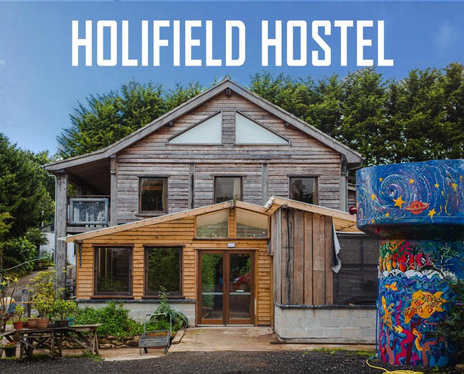 ein Holzhaus mit den Worten, die oben verschraubt sind in der Unterkunft Holifield Farm Hostel & Community Project in Helston