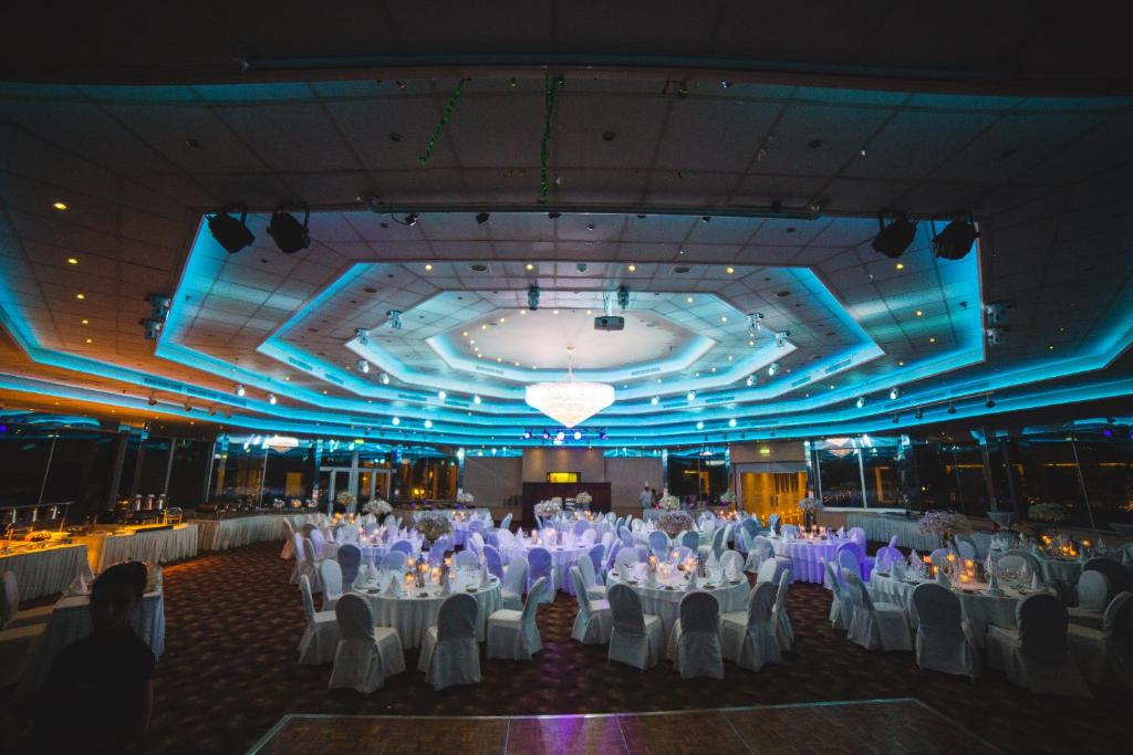 a large banquet hall with white tables and chairs at St Raphael Resort in Limassol