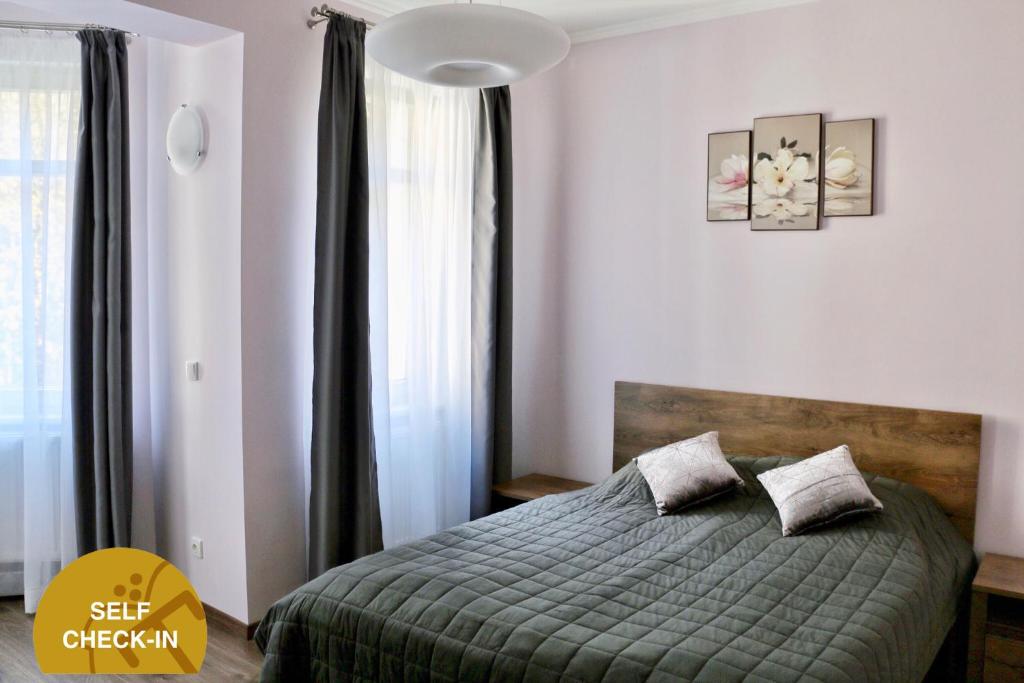 a bedroom with a bed with a green comforter at Apartments Moravská 24 in Karlovy Vary