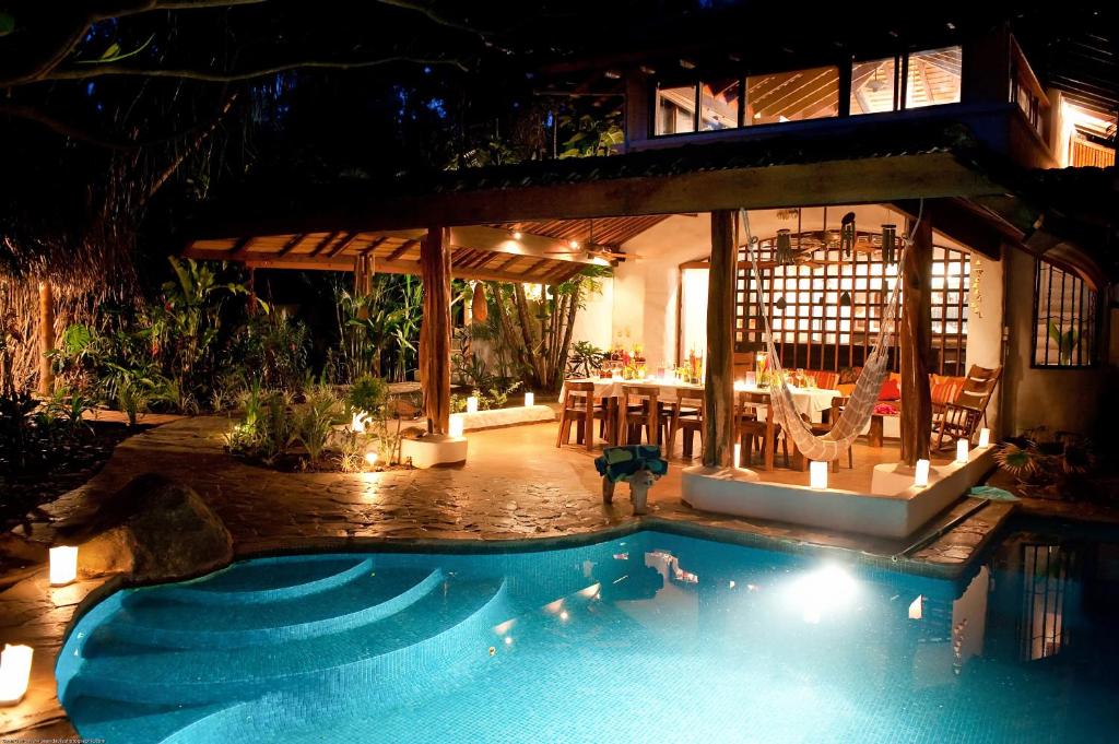 a swimming pool in front of a villa at night at Sueño del Mar Beachfront Hotel in Tamarindo