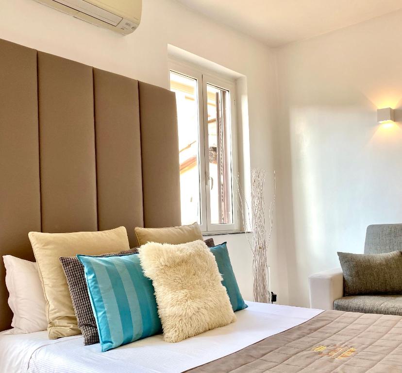 Un dormitorio con una cama con almohadas azules y blancas. en Fontana Di Trevi Luxury Apartments, en Roma