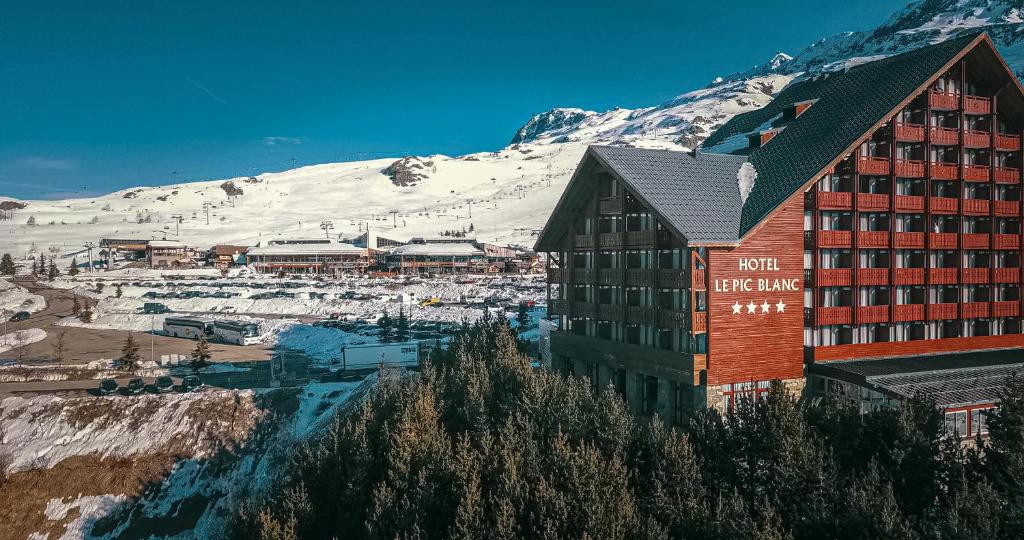 a hotel building with a mountain in the background at Le Pic Blanc in L'Alpe-d'Huez